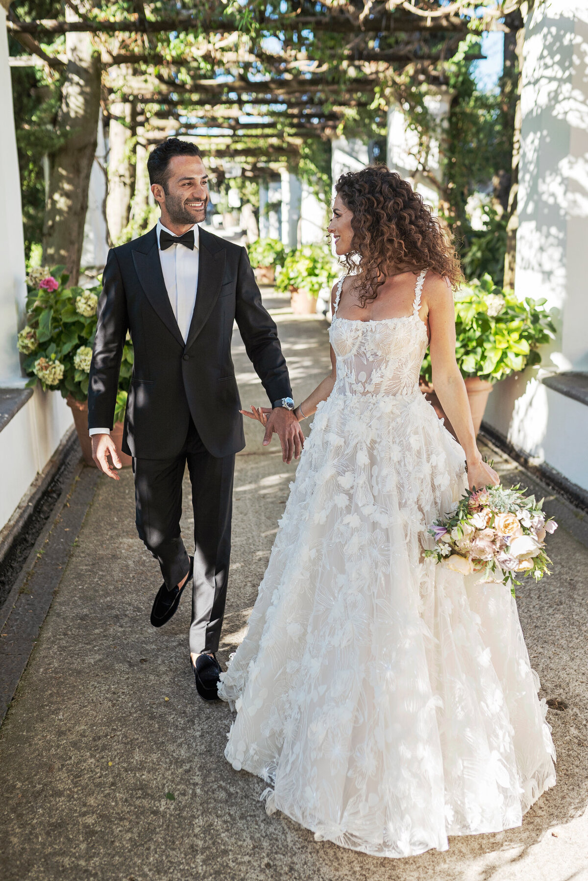 Bride and groom walking  at hotel Caruso garden
