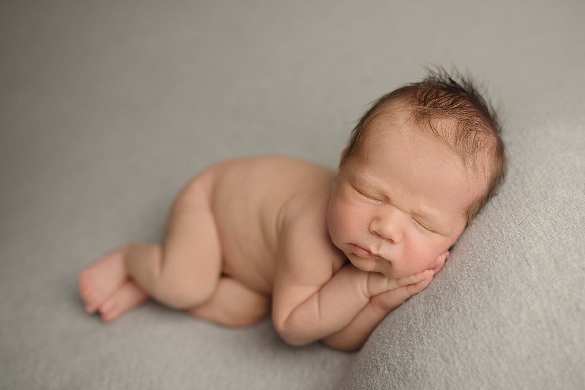 Sleeping newborn with hands under cheek
