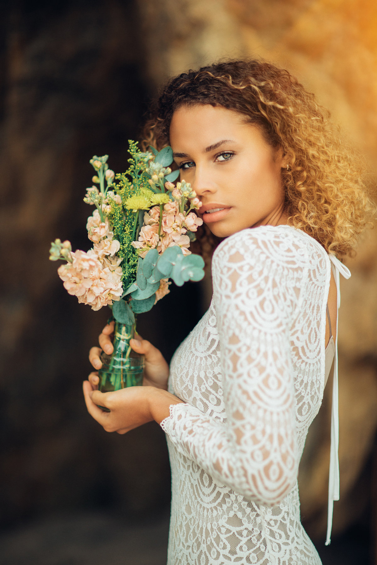 Portrait Photo Of Young Black Woman In White Dress Showing Flowers In a Bottle Los Angeles