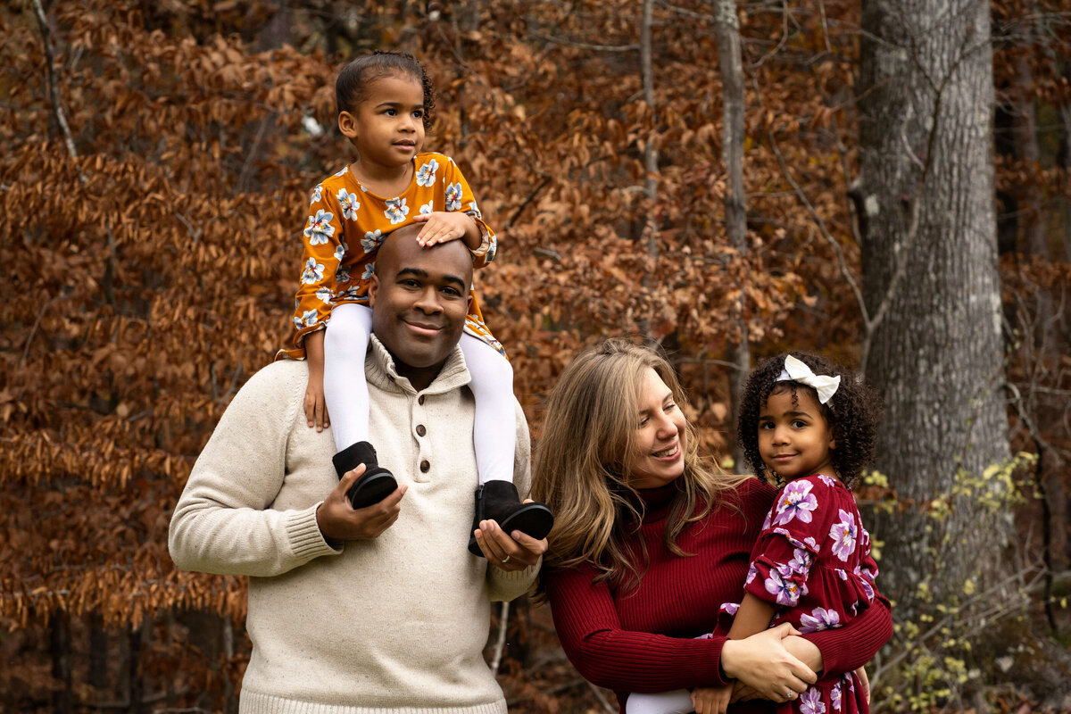 Three year old twin girls with their parents during a fall photography session outside Atlanta.