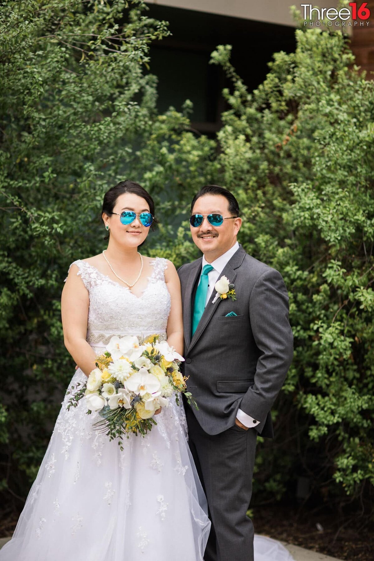 Bride and Groom pose together wearing matching sunglasses