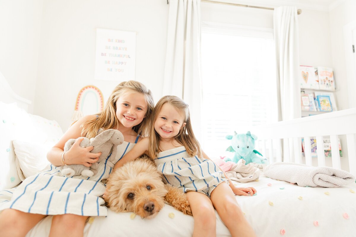 Two little girls hugging their dog at an in-home family session in Lexington KY.