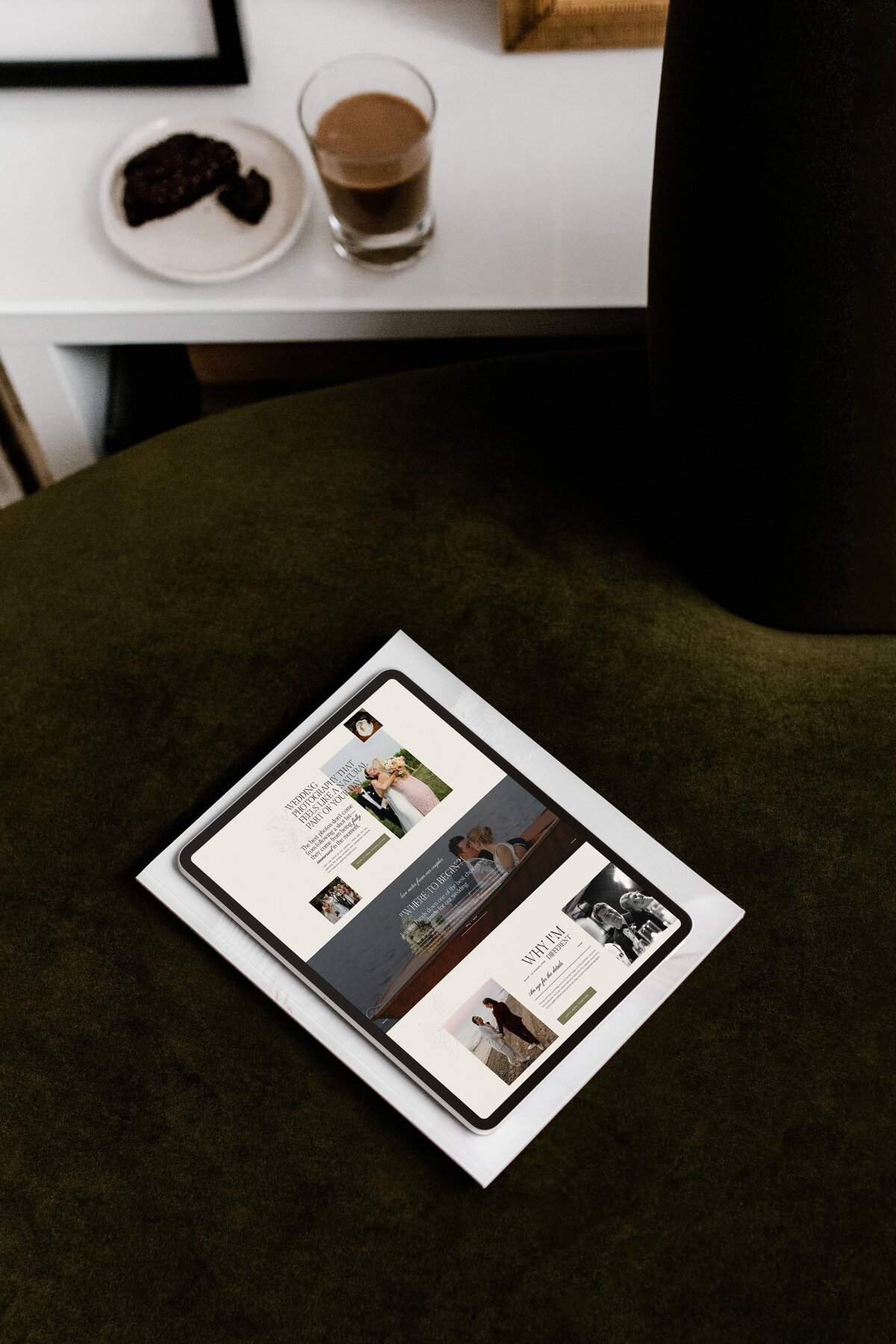 A tablet displaying a digital magazine lies on top of a folded paper on a dark green fabric surface. The magazine, featuring images and articles related to parenting and child care, showcases the elegance of showit web design for luxury photographers.