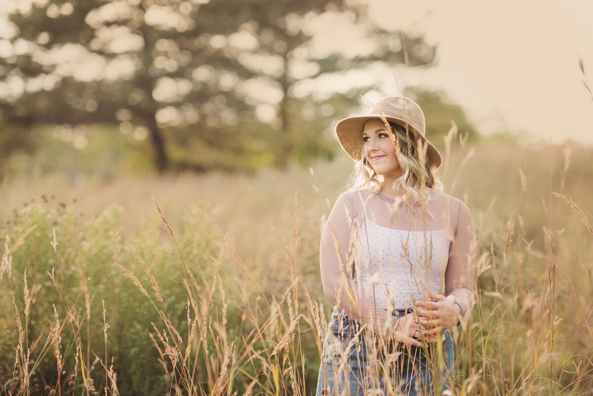 girl in long grasses and sun hat