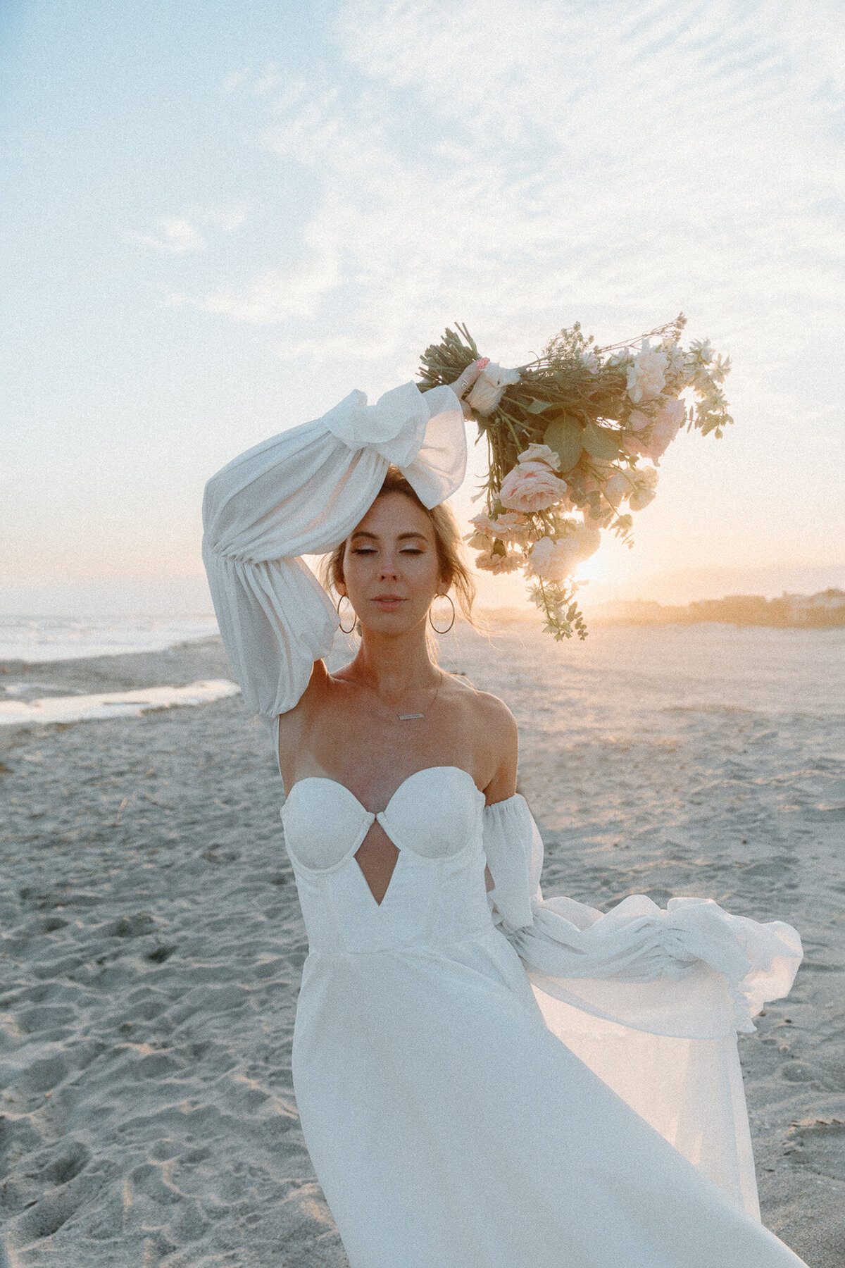 bride at sunset taking photos with bouquet pose on croatia beach