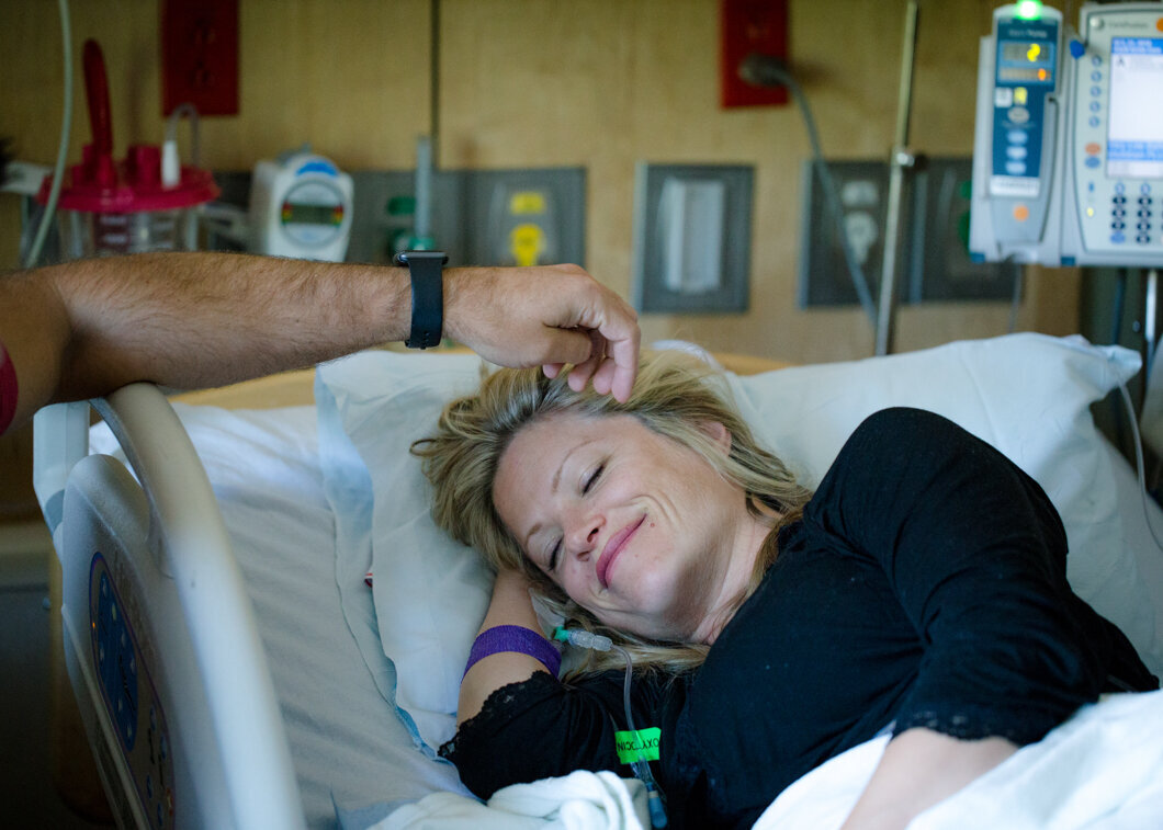 A mother smiles between contractions at her natural hospital birth. Diane Owen Photography.