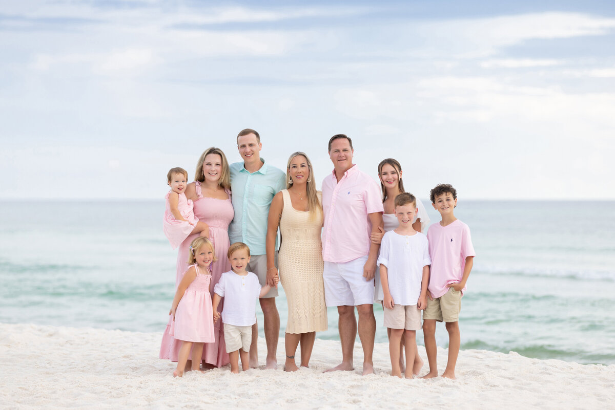 A large family standing in the sand at the beach near 30A.