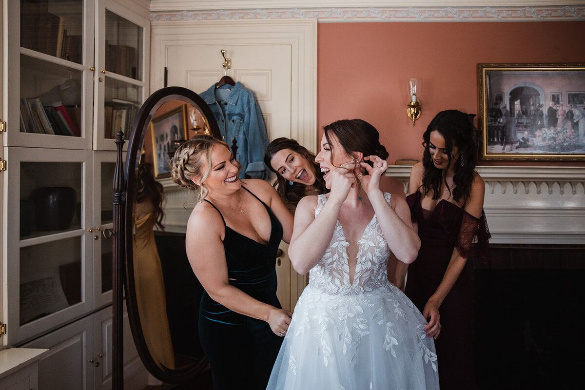 Bridesmaids having fun as they get ready with the bride