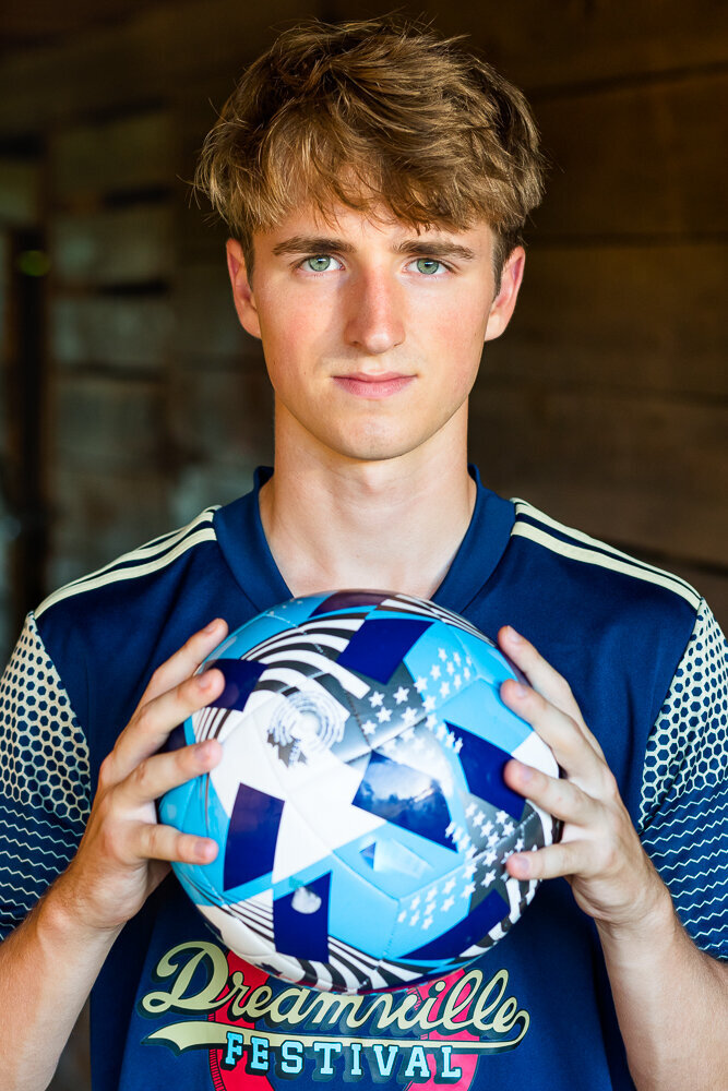 Soccer player portrait holding soccer ball in Raleigh, NC.