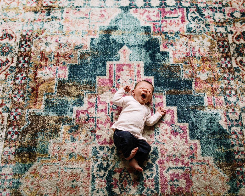 Yawning San Francisco baby on colorful geometric rug