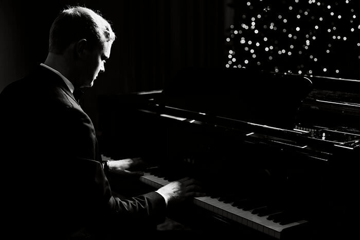 groom-plays-piano-under-lights