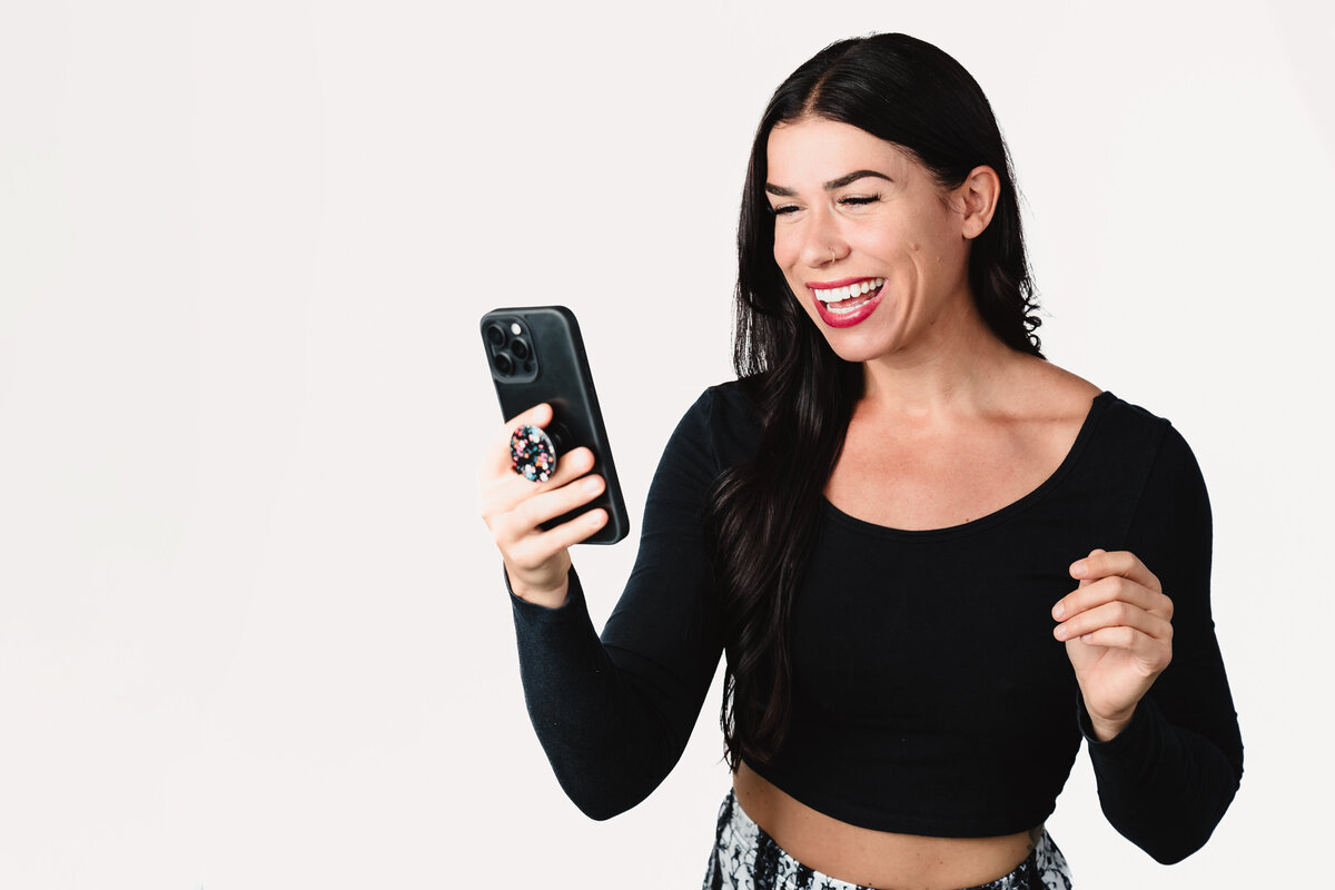 brand headshot of a Coach posing  with  her phone