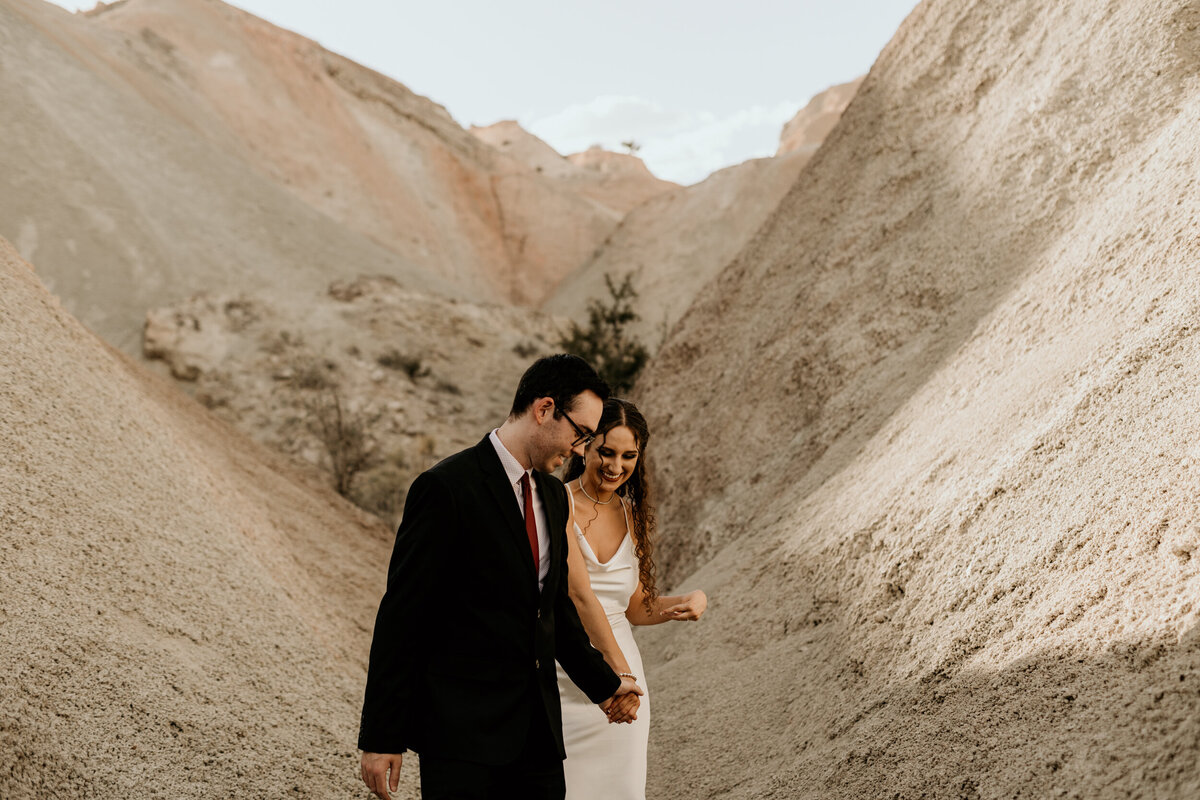 bride and groom walking  through colorful rocks together
