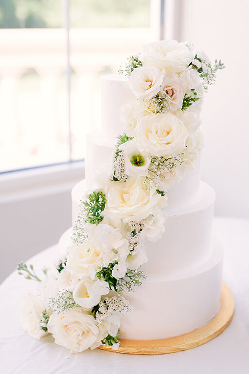 4 tiered wedding cake with white florals at luxury wedding at The Olana, Dallas
