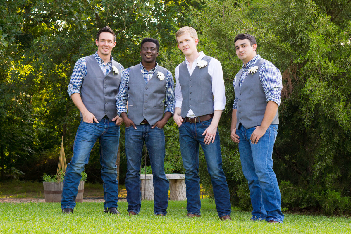 Groom and best men in grey vests and boots looking cool