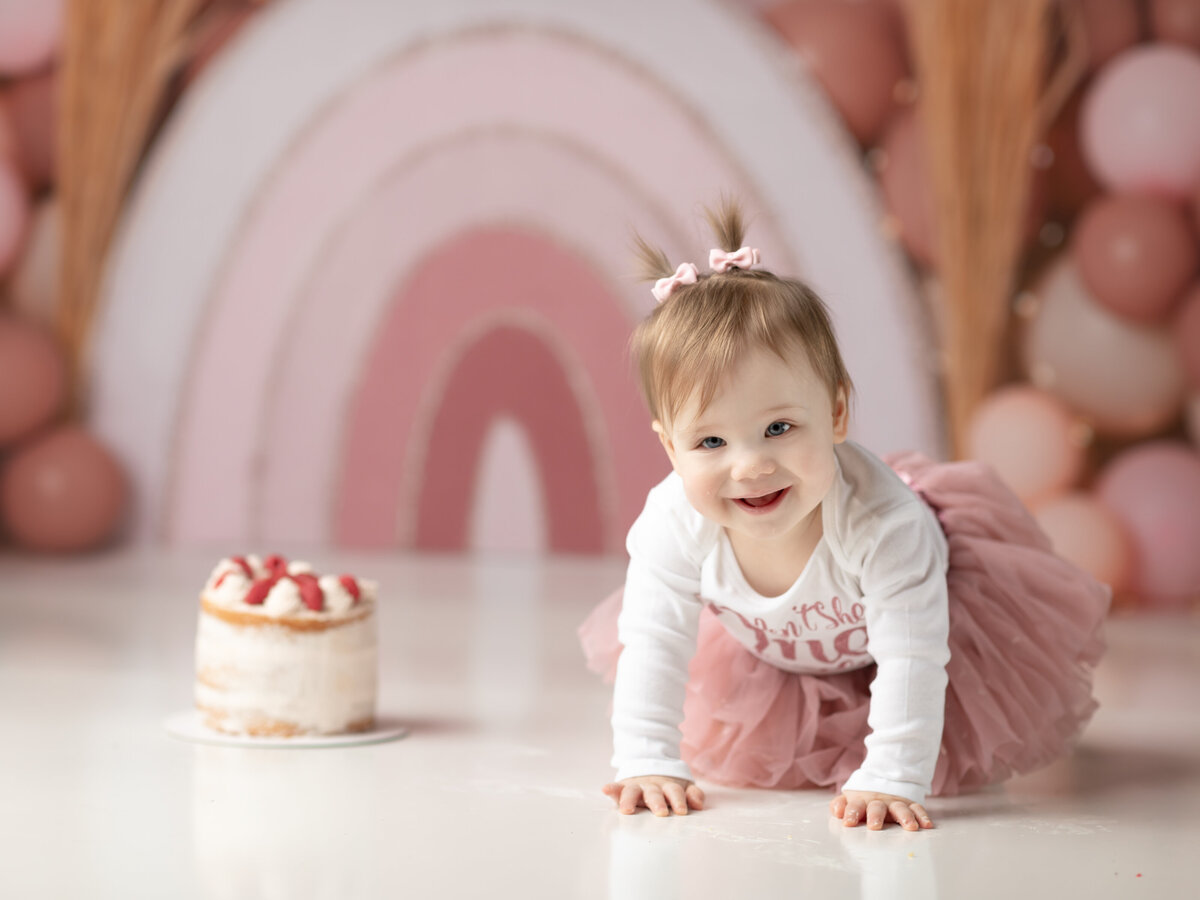 one year old girl in pink and white tutu for cake smash photography