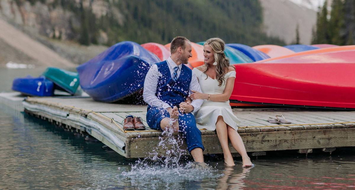 moraine lake elopement playful groom splashing bride lake canoes