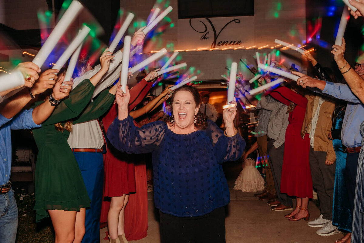 Photo of a Tennessee wedding planner celebrating in a tunnel of foam glow sticks