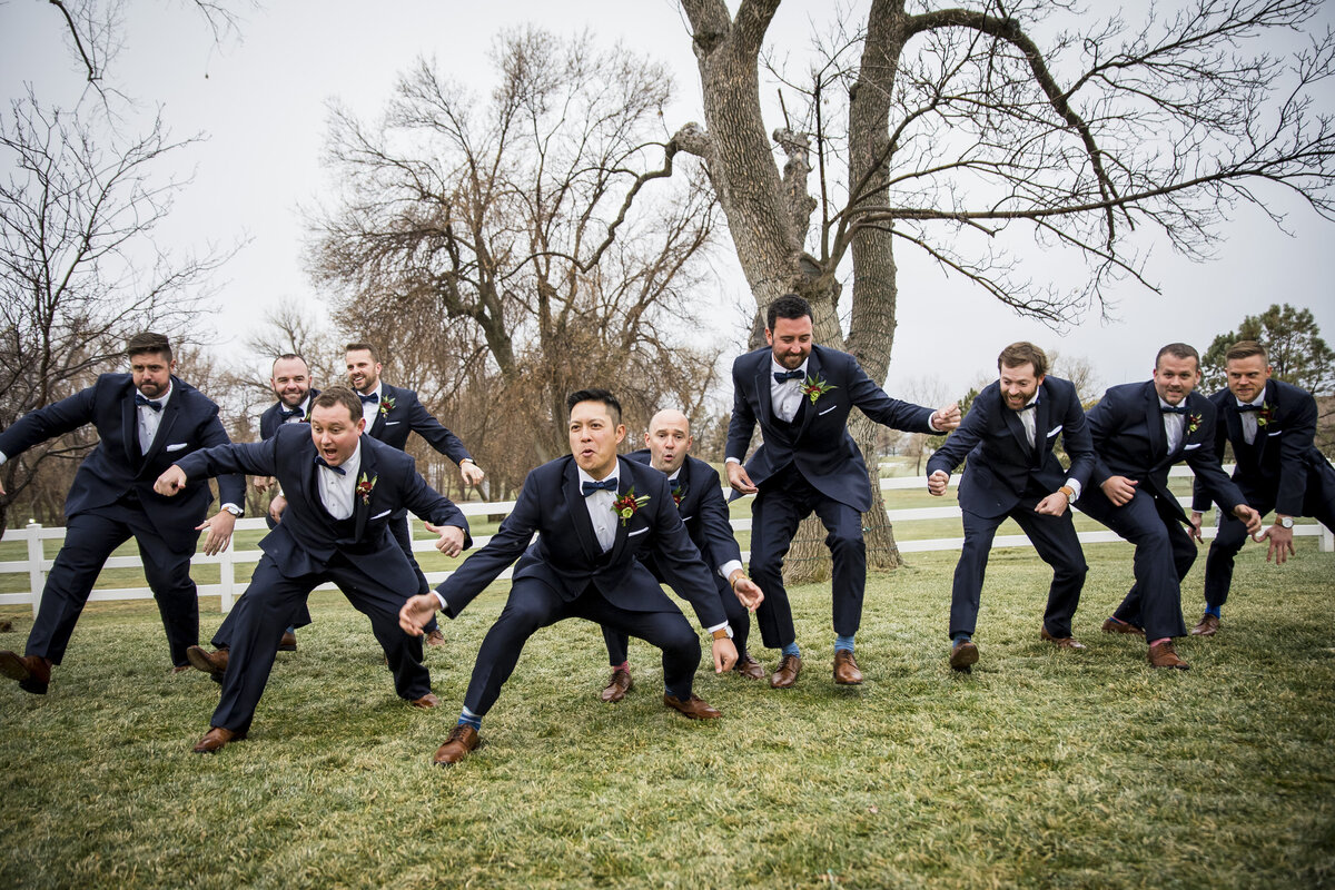 A groom and his groomsmen strike a funny squatting pose, captured by Denver wedding photographer, Casey Van Horn.