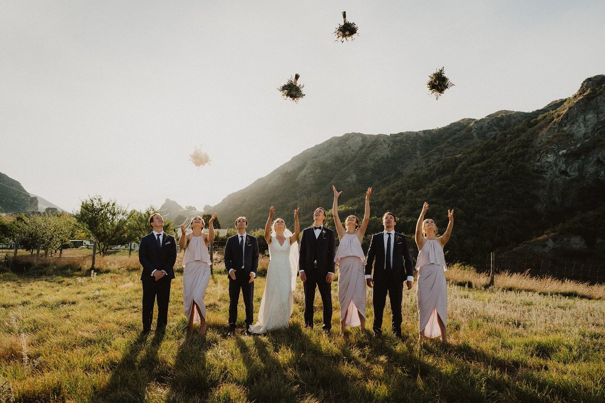 bridal party throwing bouquets in the air