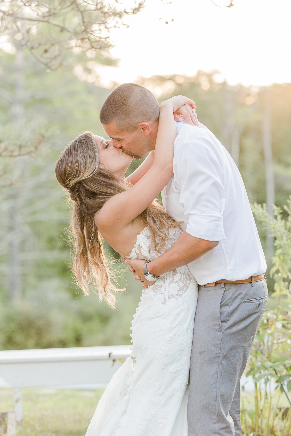 Bride and groom share a kiss at golden hour during their wedding reception at the Five Bridge Inn. Captured by best Massachusetts wedding photographer Lia Rose Weddings.