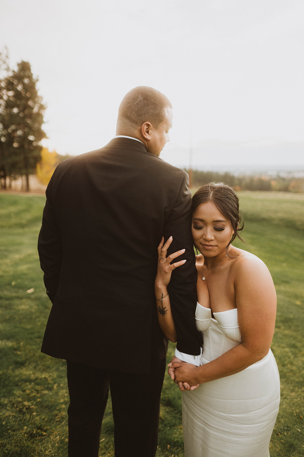 pnw wedding  photography gallery photo of bride holding her groom's arm during sunset photos
