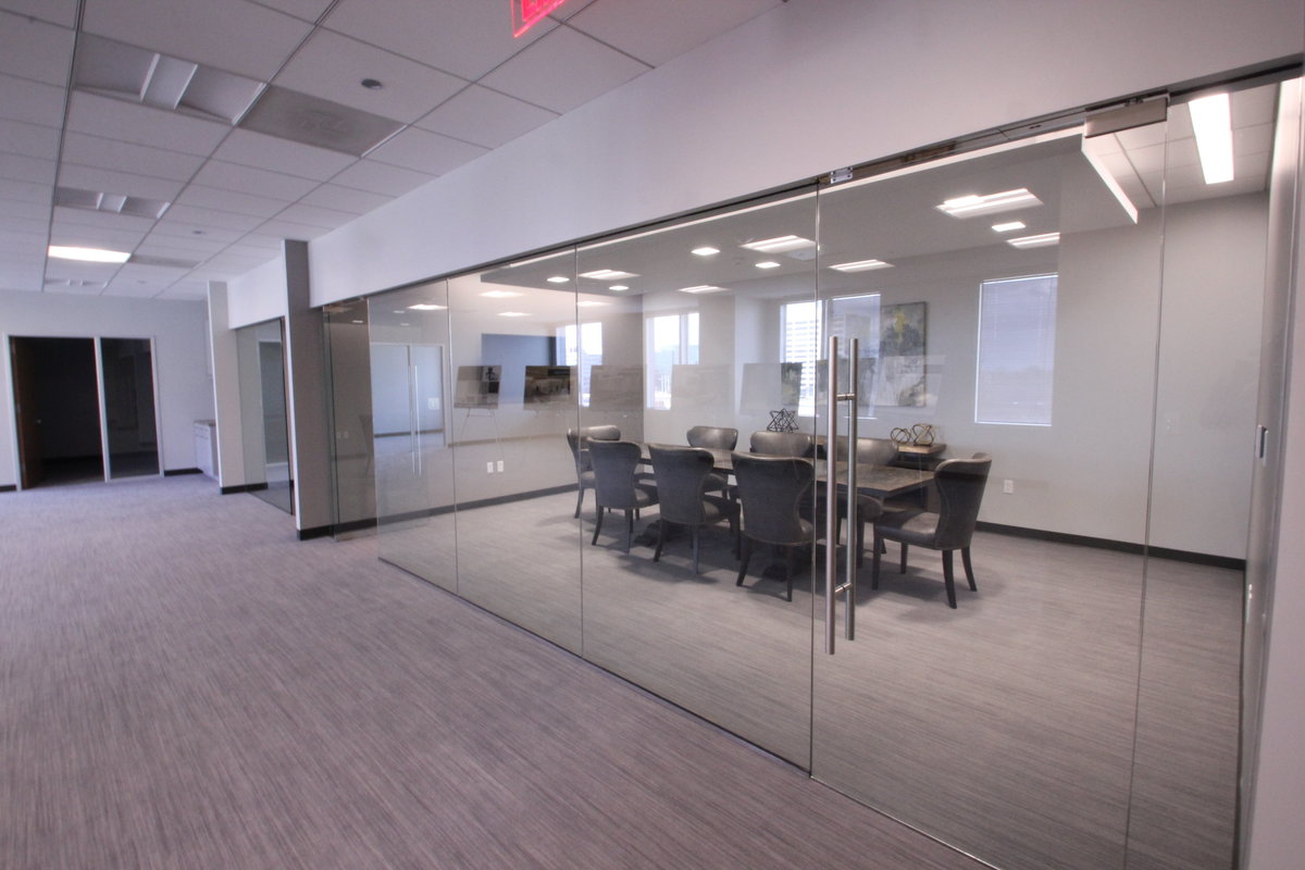 Glass doors and walls open up to commercial conference room.