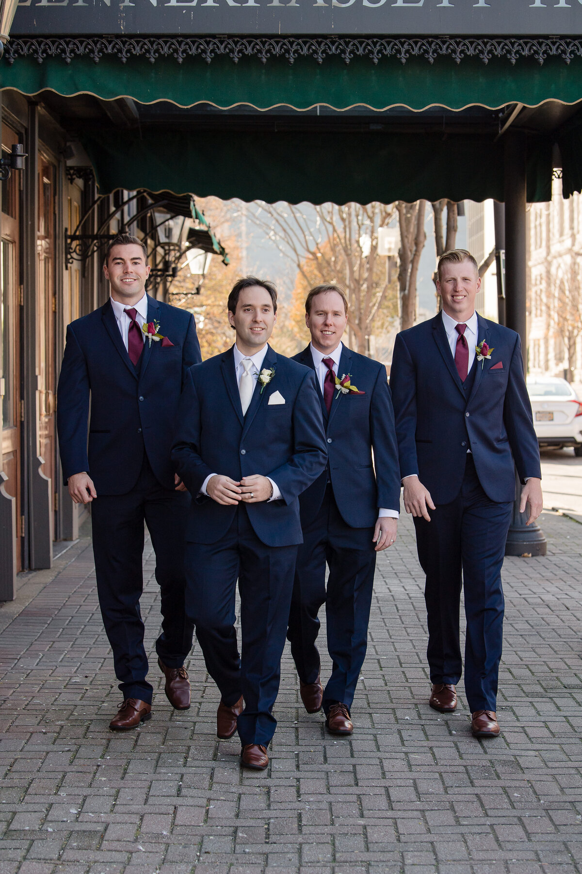 groom with groomsmen all in blue suits walking