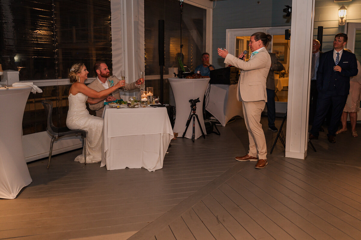 The best man giving a toast during a wedding reception on Atlantic beach by JoLynn Photography, a Raleigh wedding photographer