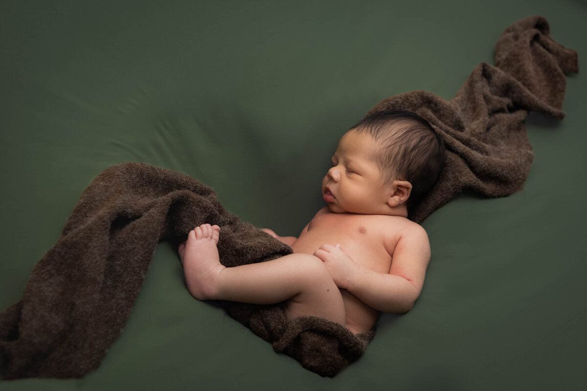 Newborn photo with swaddling draped in sunken heart