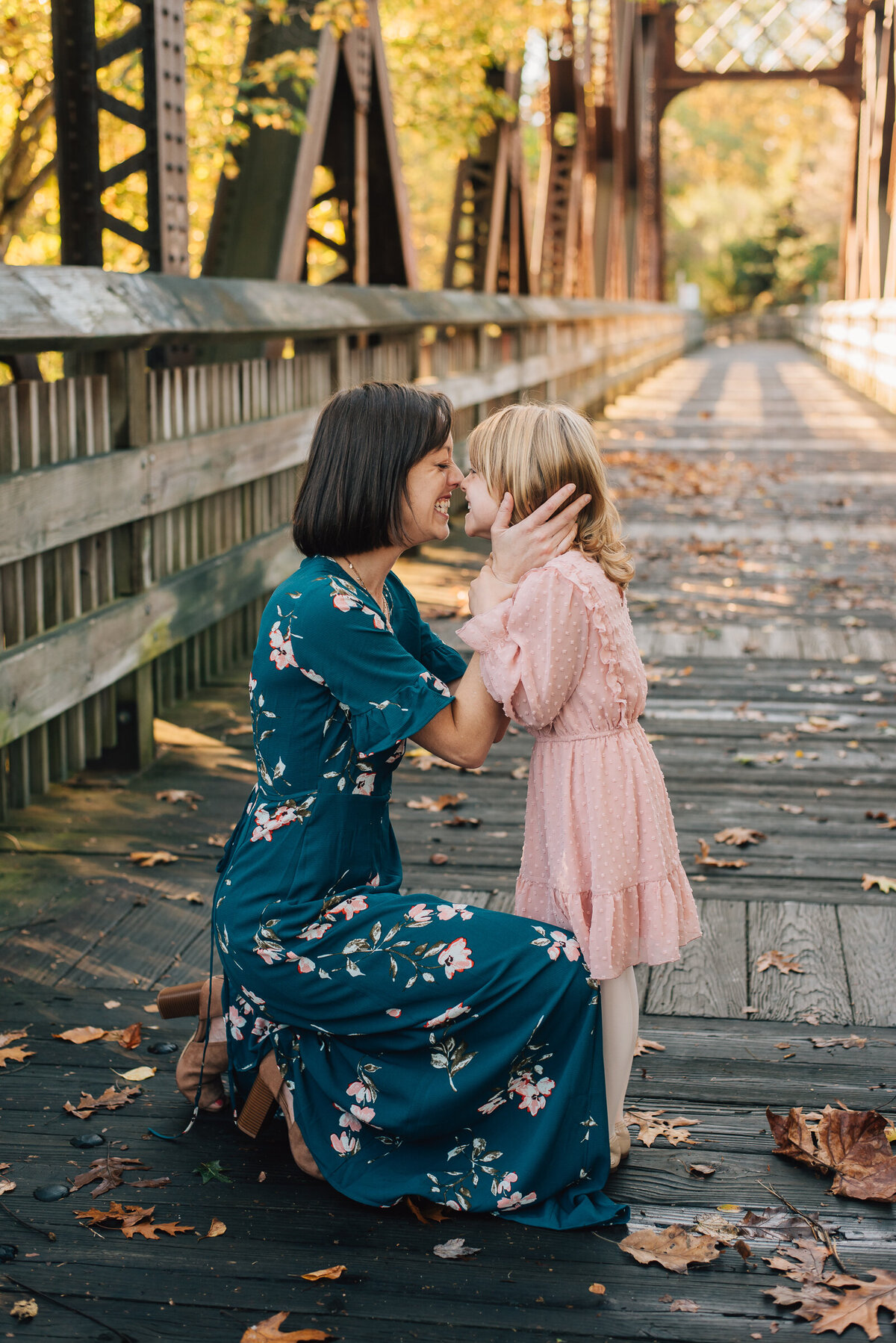 A mom putting her nose on her daughter's nose on a bridge in Canton, CT.