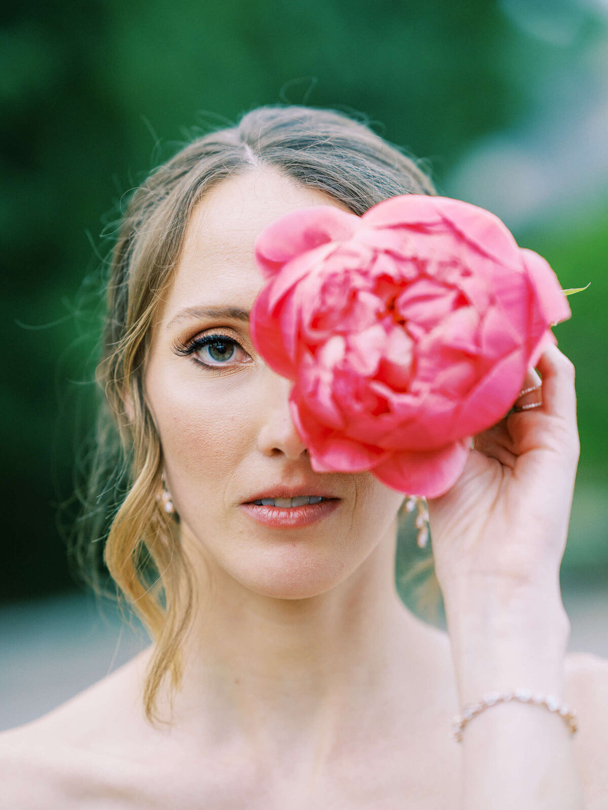 Elegant bride holds peony from colorful bridal bouquet