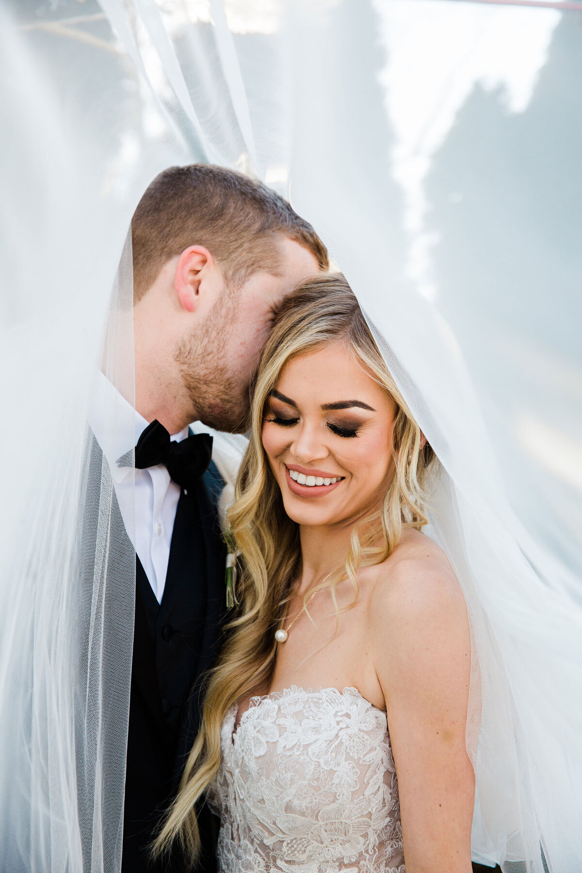 bride and groom under a veil at The Julianna