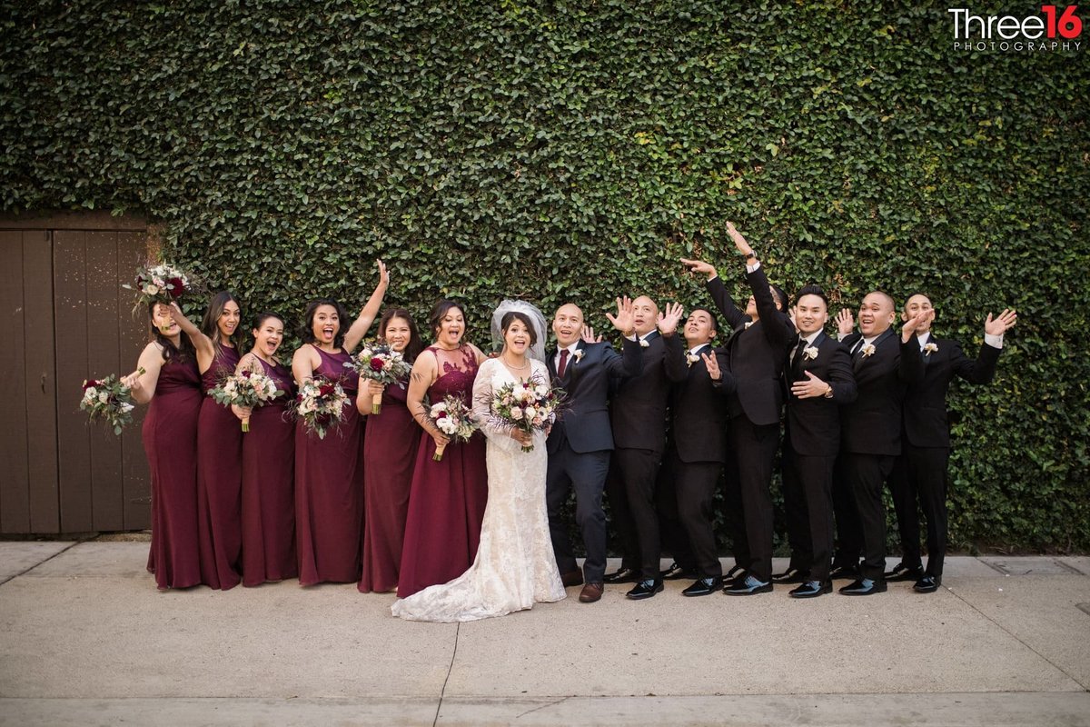 Bride and Groom pose with bridal party and everyone is cheering