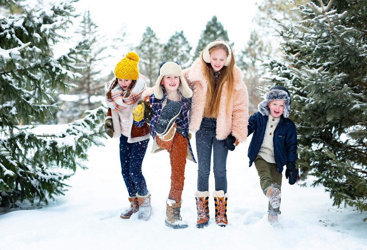 Kids kicking snow together at Arneson Acres in Minneapolis for family photos