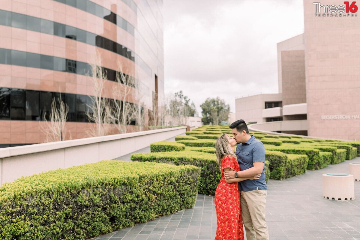Engaged couple share a kiss at the Segerstrom Center for the Arts