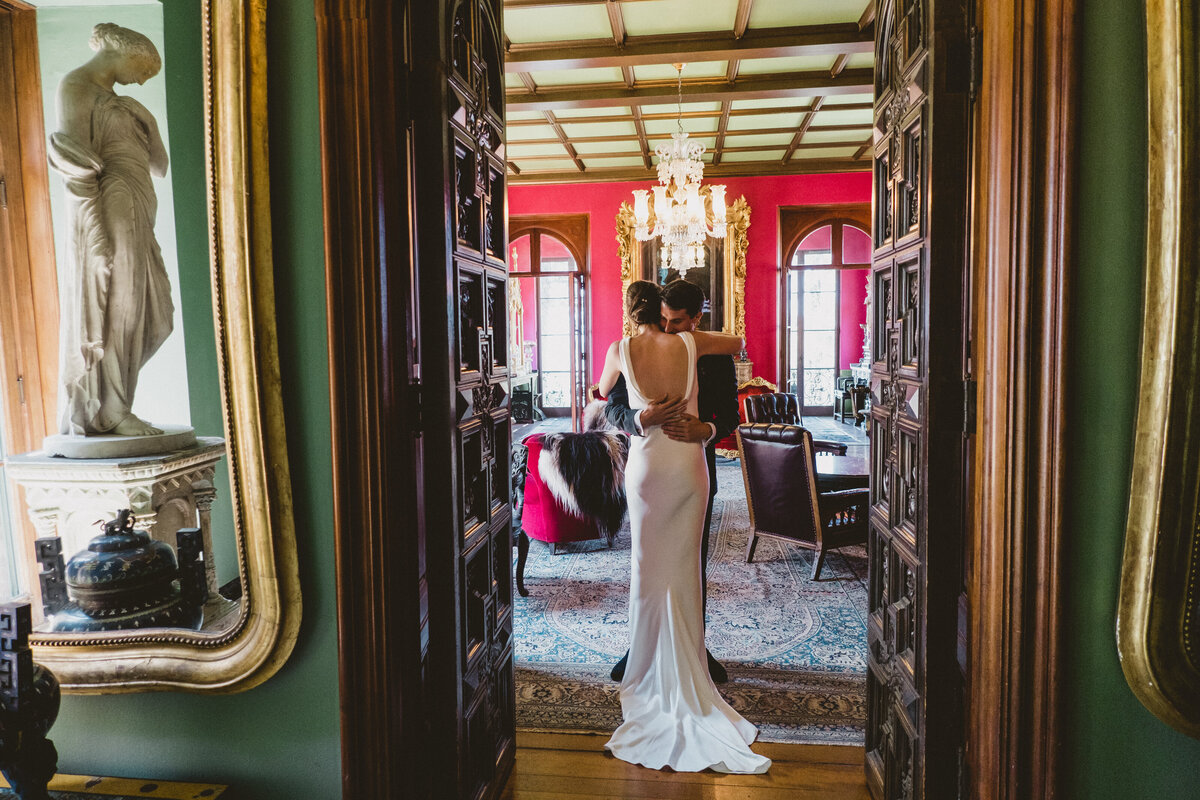 Bride and groom embrace in the ornate Paramour Mansion Salon. Romantic First Look portraits.