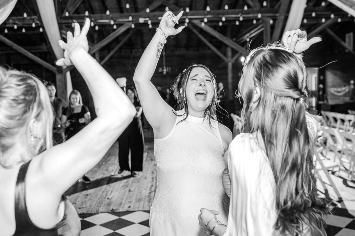 A bride dancing with her friends during her wedding reception by JoLynn Photography. a Raleigh wedding photographer