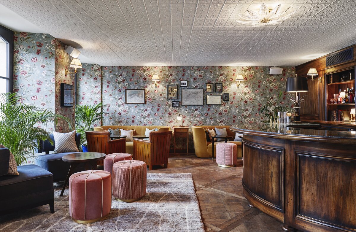 Wooden inlaid floor, floral wallpaper, white tin ceiling, vintage furniture and wooden panelled bar