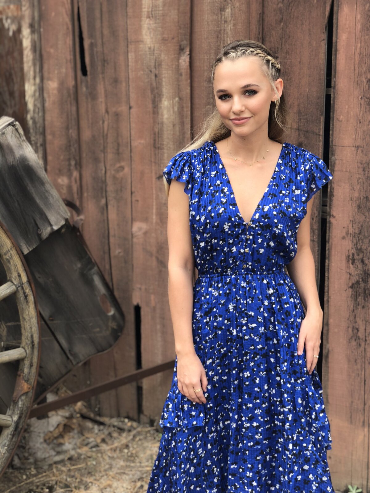 Madison Iseman in a blue dress and braided hair