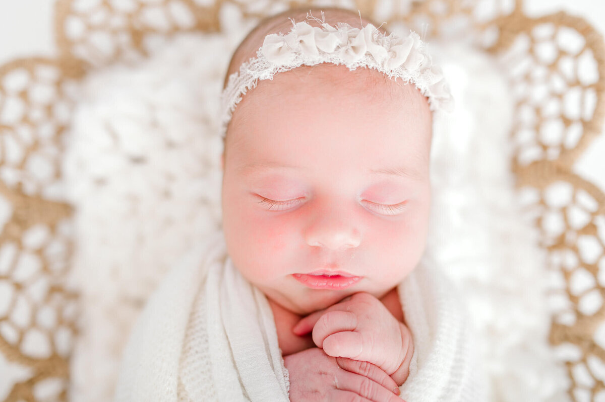 Close up of baby girl showing her little hands and facial features