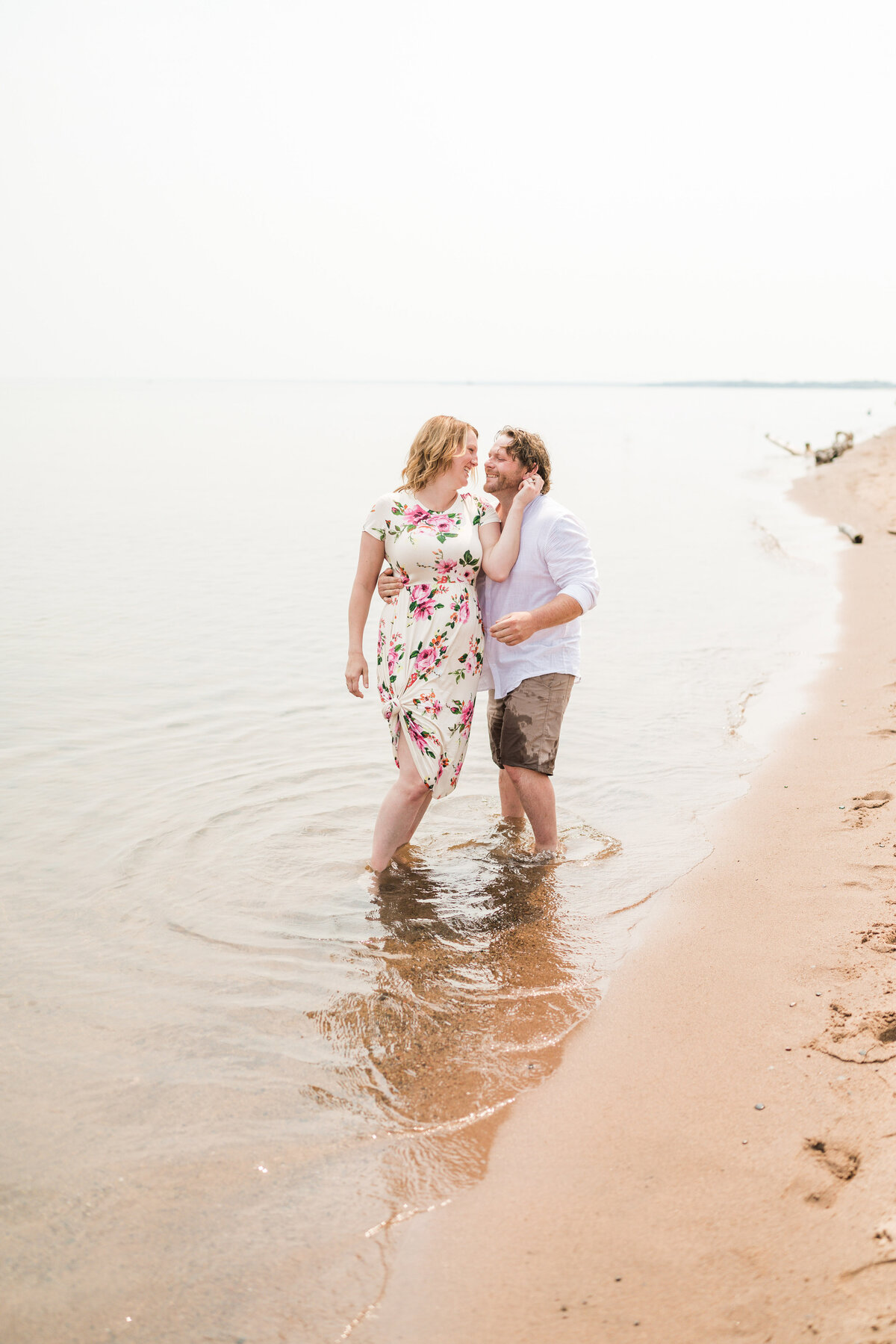 Man and woman kiss while standing in Lake Superior.