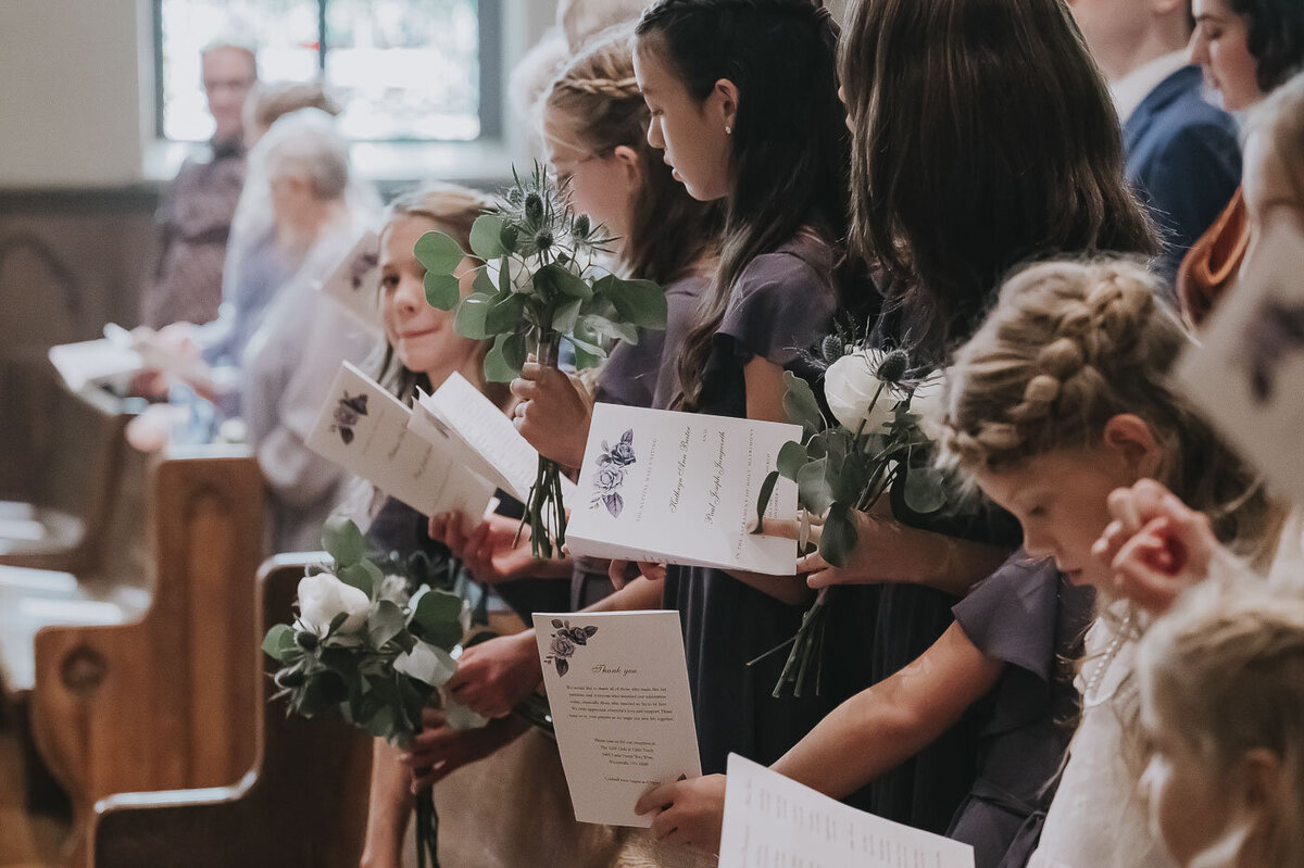 guests holding programs at a Catholic wedding