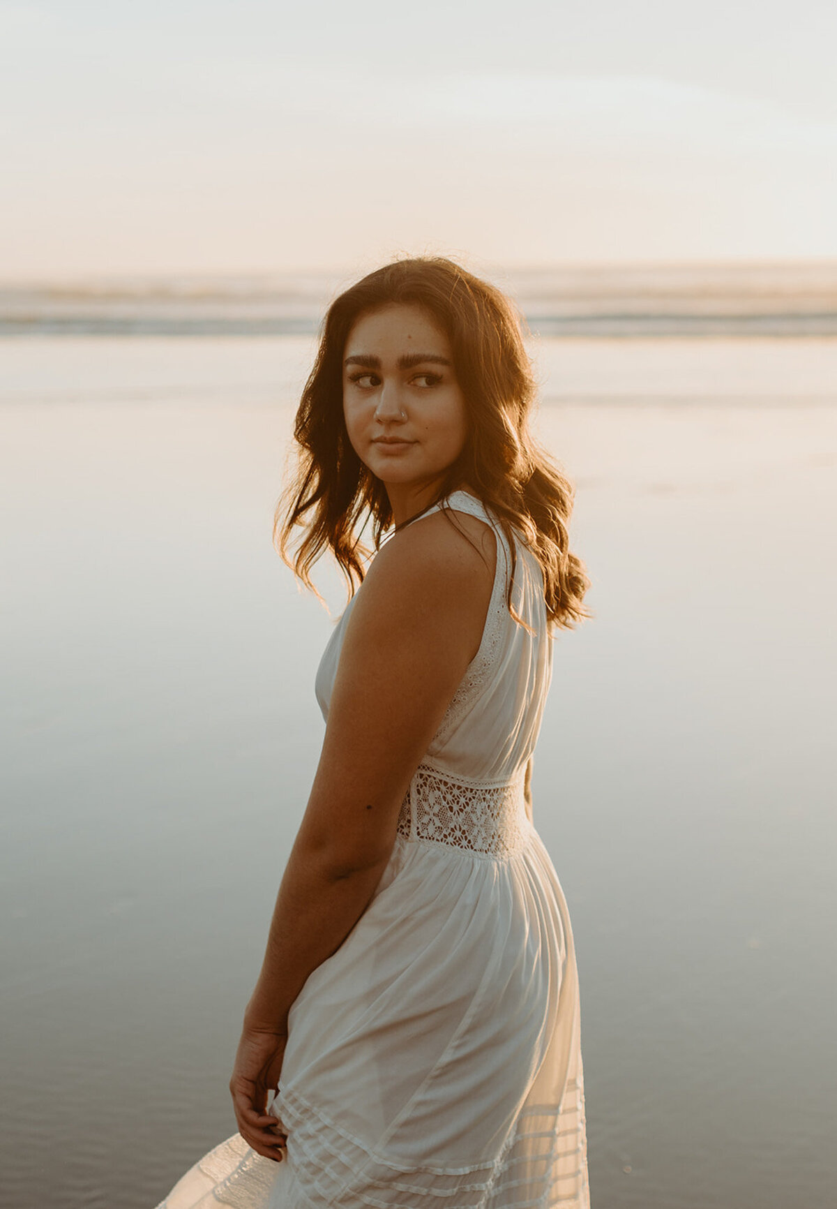 girl in white dress posing on beach