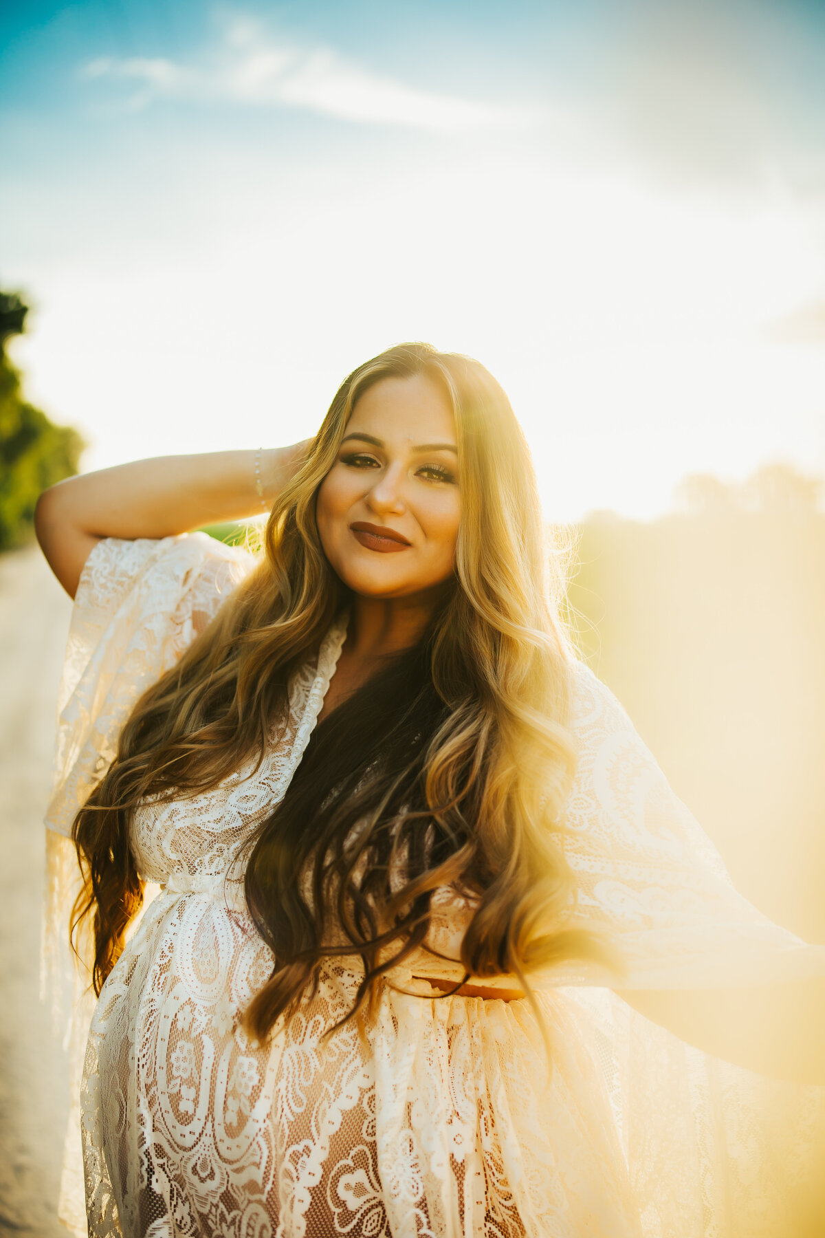 stunning golden hour pregnancy portraits taken at a farm in hillsborough county fl with a white boho lace maternity dress