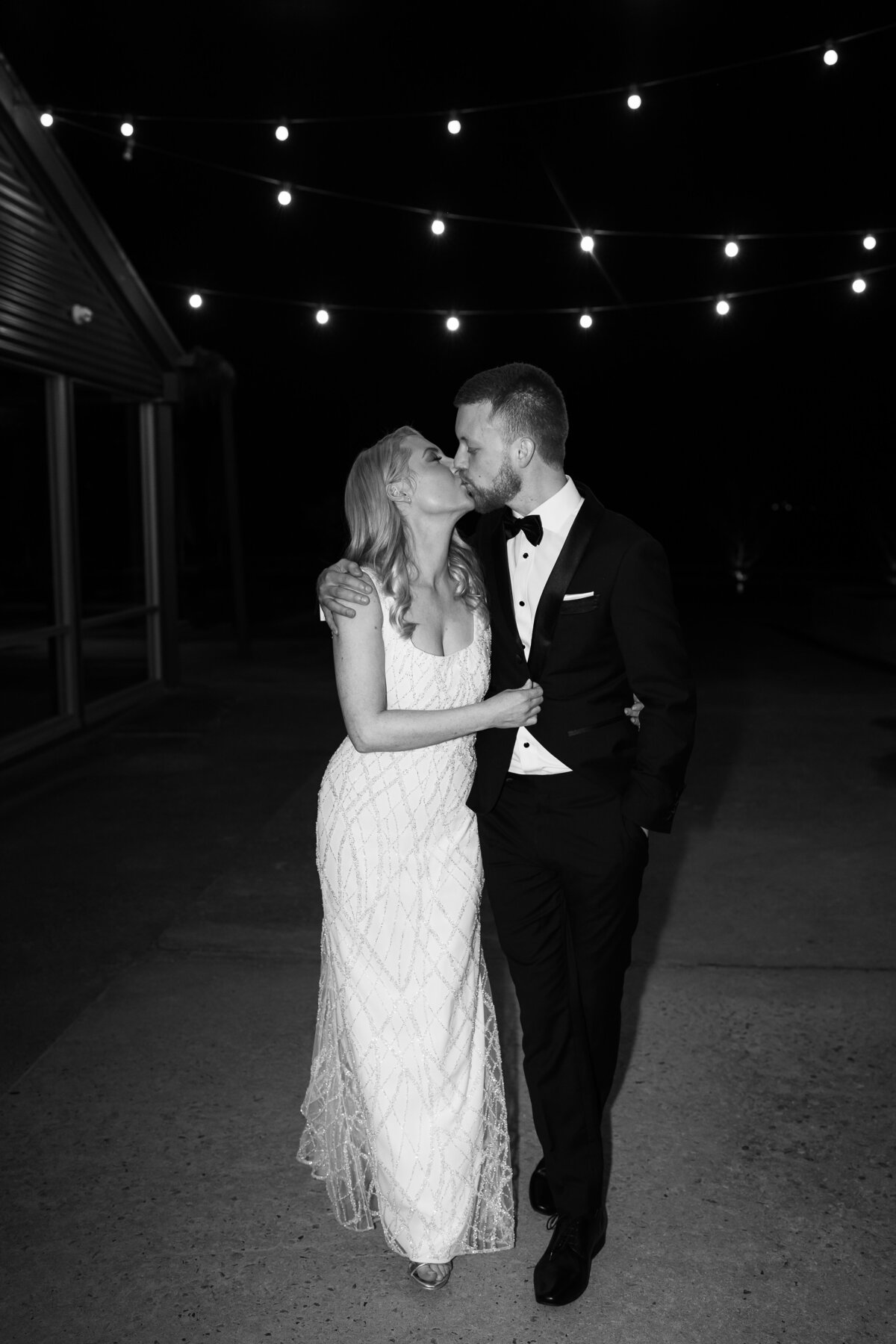 Yarra Valley Wedding at Zonzo Estate with bride and groom kissing as that walk towards me with arms around each other and in the dark with flash photography