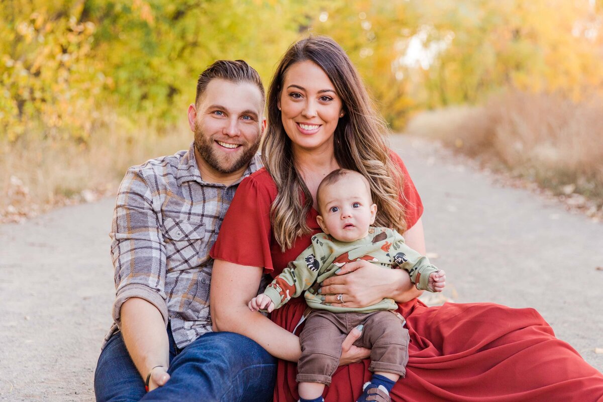 Family sits on pathway with baby at Golden Ponds, Longmont, CO