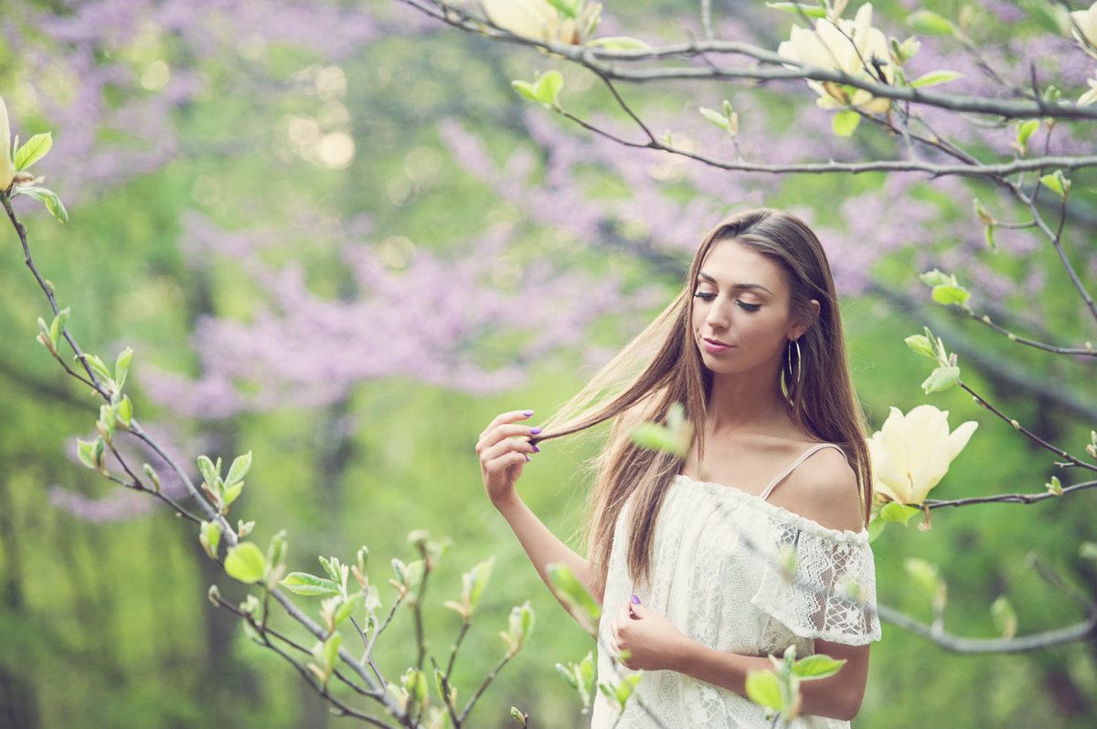 high school senior photo of girl in purple and green trees with white dress