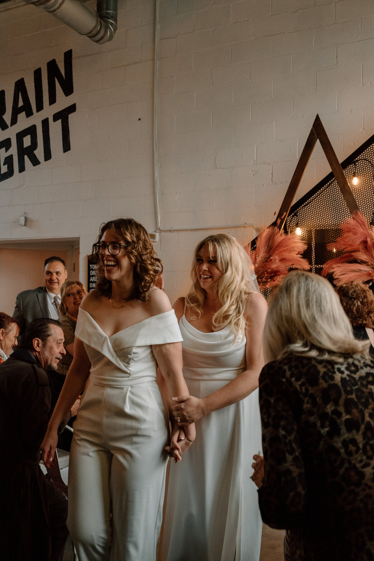 brides walk back down the aisle at their brewery wedding