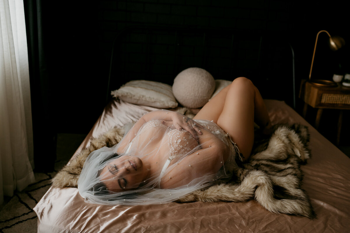 woman wearing a veil laying on a bed